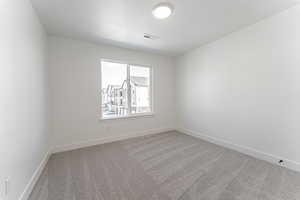 Carpeted spare room with a textured ceiling