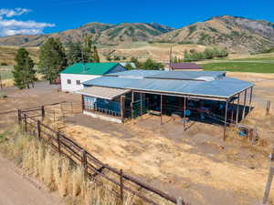 View of front of property featuring a mountain view, a rural view, and an outdoor structure