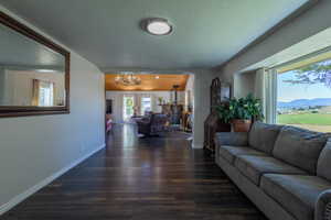 Living room with an inviting chandelier, dark wood-type flooring, a mountain view, and a textured ceiling