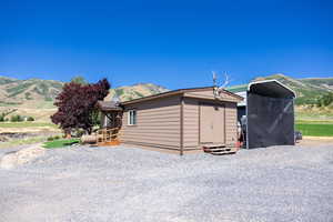 View of home's exterior with a mountain view and a storage shed