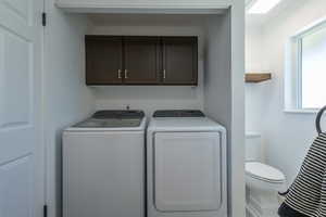 Clothes washing area with separate washer and dryer and plenty of natural light