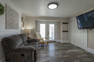 Living room featuring french doors, dark hardwood / wood-style flooring, and a textured ceiling