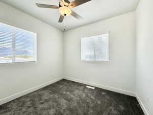 Carpeted empty room with ceiling fan