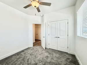 Unfurnished bedroom with ceiling fan, carpet flooring, and a closet