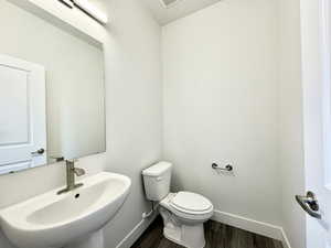 Bathroom with sink, toilet, and hardwood / wood-style floors