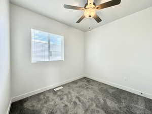 Carpeted empty room featuring ceiling fan