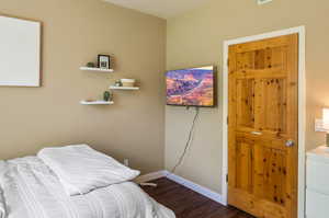 Bedroom with dark hardwood / wood-style floors