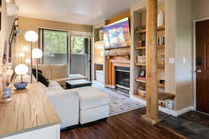 Living room featuring built in shelves and dark hardwood / wood-style flooring