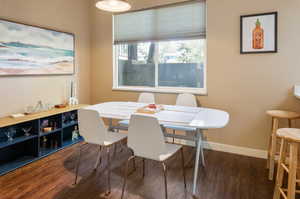 Dining space with dark hardwood / wood-style flooring