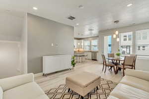 Living room featuring light hardwood / wood-style flooring and a textured ceiling