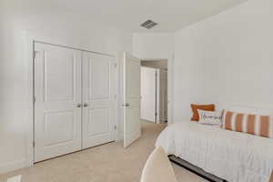 Carpeted bedroom with a closet