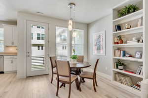 Dining room with light hardwood / wood-style flooring and a textured ceiling