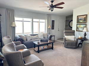 Living room with carpet floors, a textured ceiling, and ceiling fan