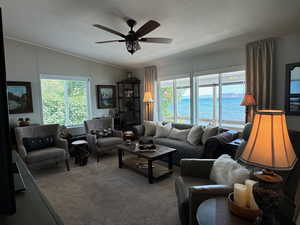 Living room with a textured ceiling, a water view, a wealth of natural light, and ceiling fan