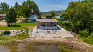 Back of house with a water view and a yard