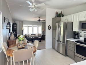 Kitchen featuring appliances with stainless steel finishes, light carpet, tasteful backsplash, and gray cabinetry