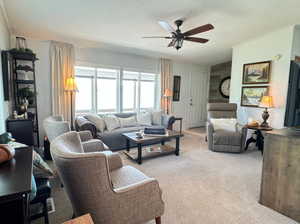 Carpeted living room featuring ceiling fan