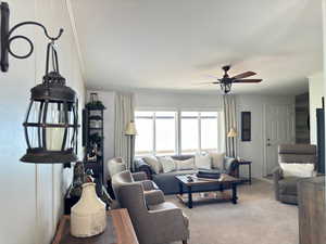 Living room with carpet floors and ceiling fan