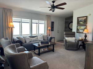 Living room with carpet flooring and ceiling fan