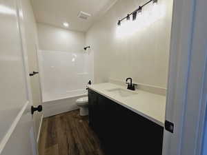 Full bathroom with toilet, hardwood / wood-style floors, vanity, and  shower combination