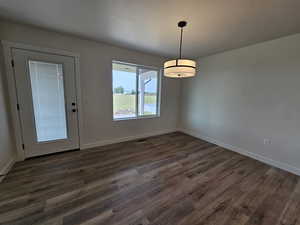 Empty room featuring dark hardwood / wood-style flooring