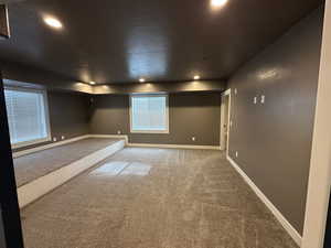 Carpeted empty room featuring baseboards and recessed lighting
