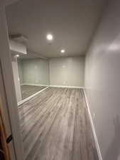Finished below grade area with wood finished floors, baseboards, and recessed lighting