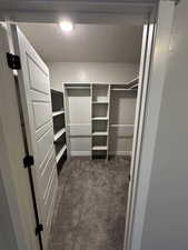 Walk in closet featuring dark carpet