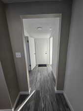 Hall with dark hardwood / wood-style flooring and a textured ceiling