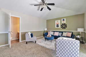 Carpeted living room featuring ceiling fan