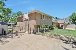 Back of property featuring lawn, basketball, and RV parking