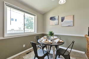 Dining room featuring tile patterned floors and lofted ceiling