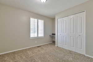 Unfurnished bedroom with carpet flooring and a closet