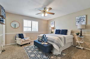 Carpeted bedroom with a textured ceiling and ceiling fan