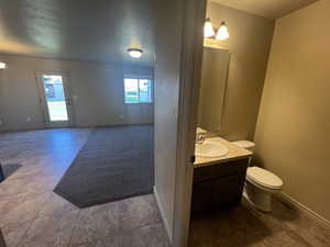 Bathroom featuring vanity, tile patterned flooring, and toilet