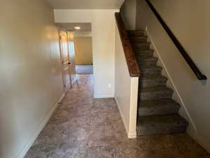 Stairs featuring dark tile patterned flooring