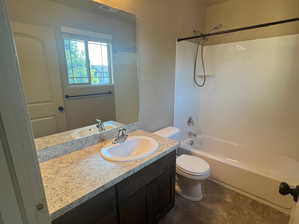 Full bathroom with bathing tub / shower combination, vanity, tile patterned flooring, and toilet