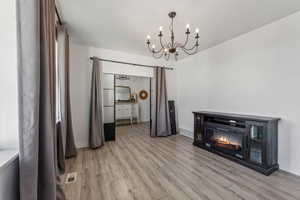 Unfurnished dining area with a notable chandelier and light hardwood / wood-style flooring