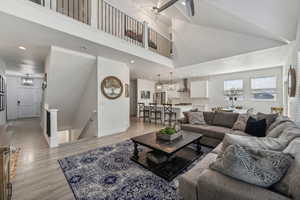 Living room featuring high vaulted ceiling and light wood-type flooring