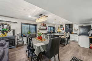 Dining space with a wall mounted air conditioner and dark hardwood / wood-style floors