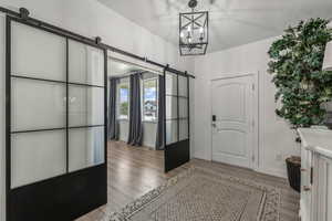 Entryway with a notable chandelier, light hardwood / wood-style flooring, and a barn door