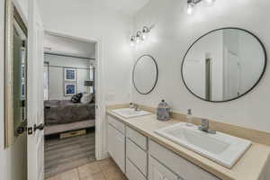 Bathroom with dual vanity and hardwood / wood-style floors