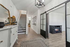 Interior space featuring a chandelier, light hardwood / wood-style flooring, and a barn door