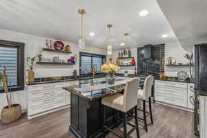 Kitchen featuring wall chimney range hood, white cabinets, and dark hardwood / wood-style floors