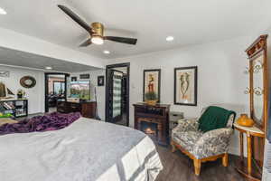 Bedroom with ceiling fan and dark wood-type flooring