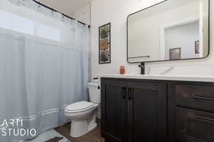 Bathroom featuring vanity, toilet, and wood-type flooring