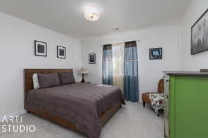 Bedroom featuring light colored carpet