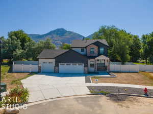 View of front facade with a garage and a mountain view