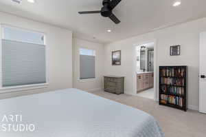 Bedroom featuring ensuite bath, ceiling fan, and light colored carpet