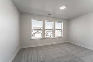 Unfurnished room with light carpet and a textured ceiling